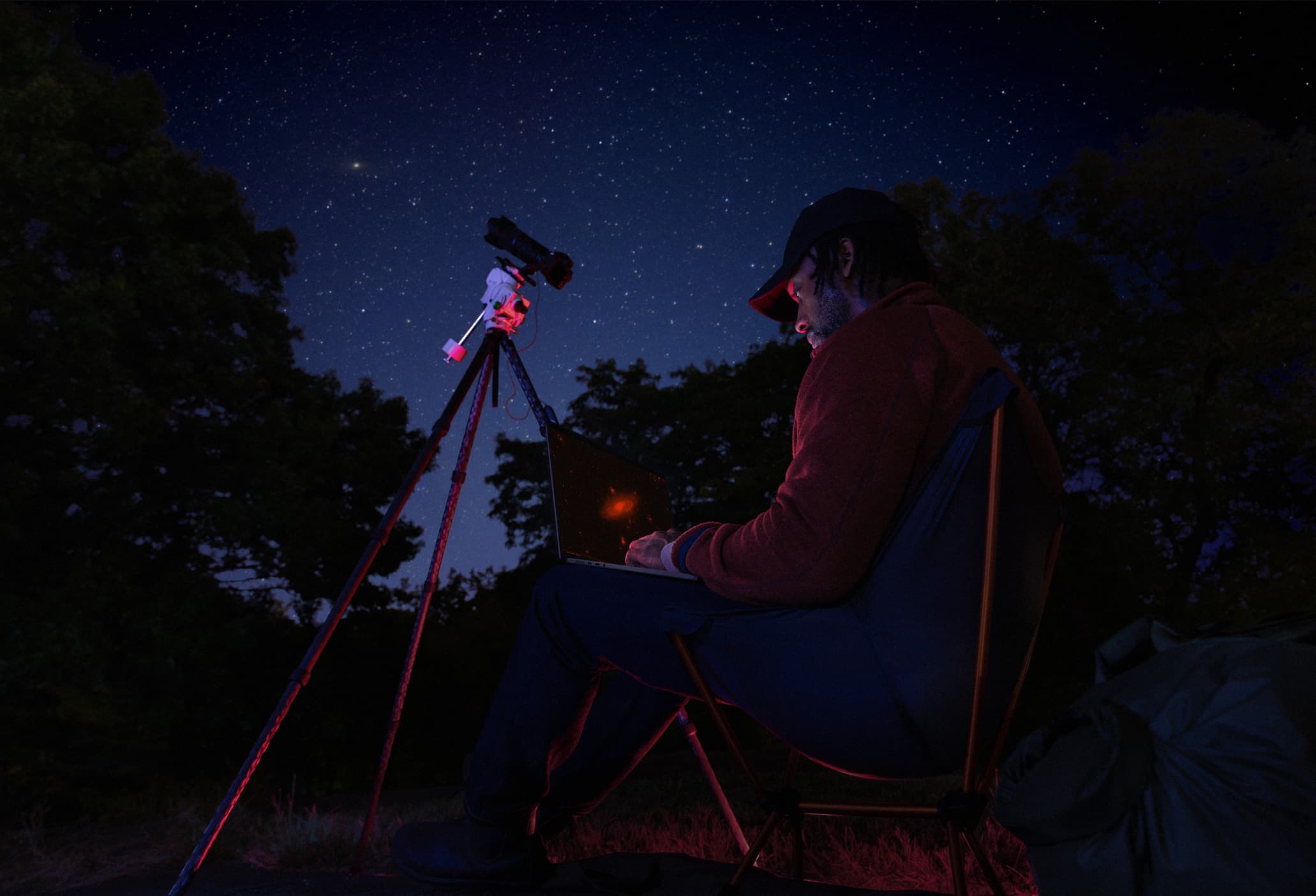 Person coding under starlight sky with MacBook Pro battery life